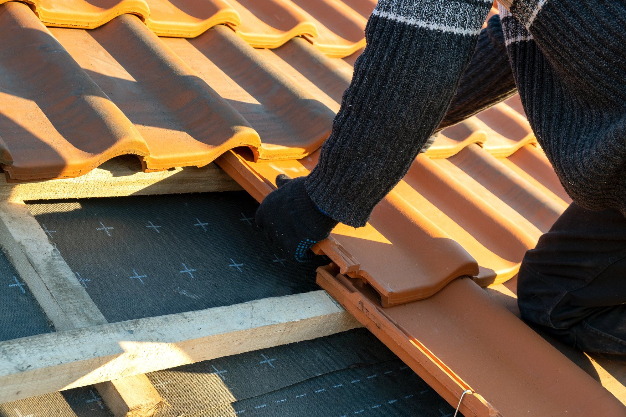 Roofer fitting clay roof tiles